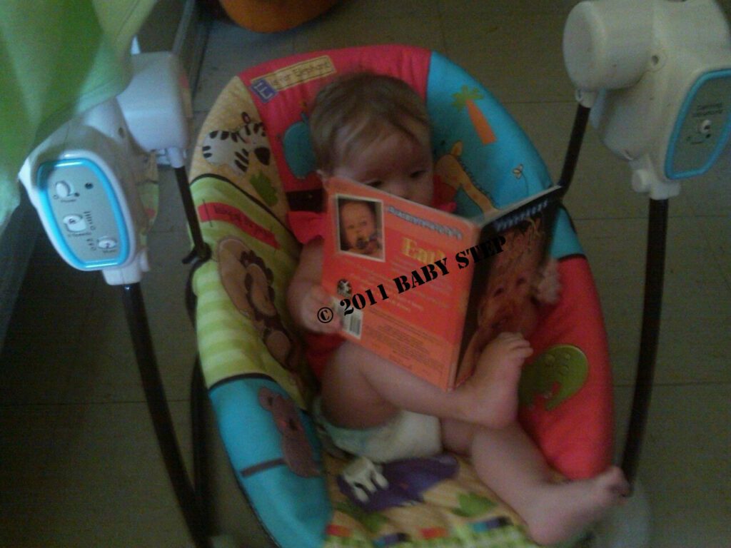 baby on a baby carry reading a book